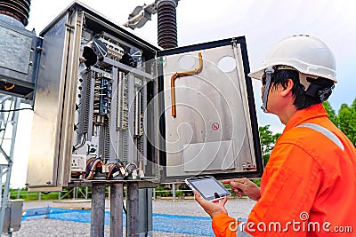 Engineers are checking the operation of the system by laptop, weekly check the system of the power distribution station for errors Stock Photo
