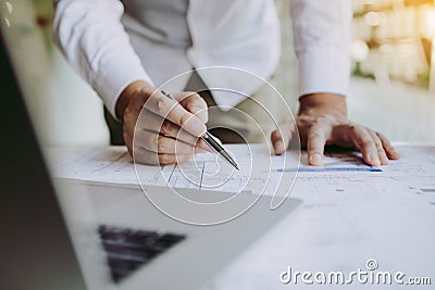 Engineers are helping to design work on blueprints and collaborate on structural analyzing of project types Stock Photo