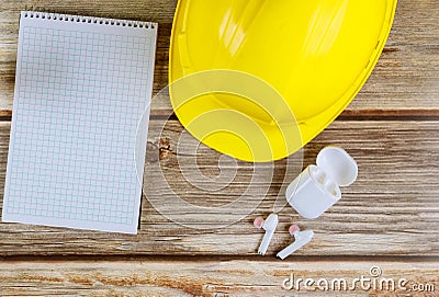 Engineers maintenance office construction, hard hat with notepad wireless headphones on vintage wood board Stock Photo