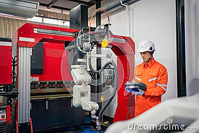 Engineers mechanic using computer controller Robotic arm for welding steel in steel factory workshop. Industry robot programming Stock Photo