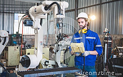 Engineers mechanic using computer controller Robotic arm for welding steel in steel factory workshop. Industry robot programming Stock Photo