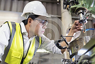 Engineers and skilled technicians are maintaining machinery. Mechanical Engineering control lathe machine in factory Stock Photo