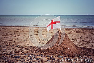 A England flag on a sand castle on a British Beach Stock Photo