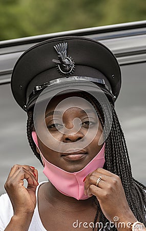Woman driver pulling on a pink face mask Stock Photo