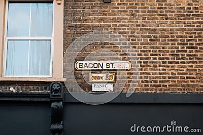 English and Bengali bilingual street name sign on a building in Bacon Street, East London, UK Editorial Stock Photo