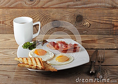 English Breakfast - scrambled eggs, bacon, fried toast and tea Stock Photo