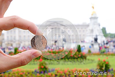 English coin picturing the Queen in front of Buckingham Palace. Editorial Stock Photo