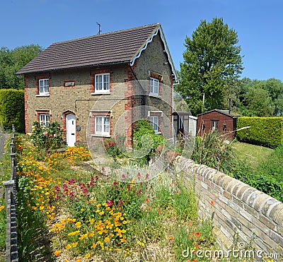 English cottage with colourful cottage garden and wall. Editorial Stock Photo