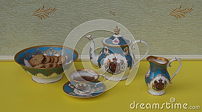 English teacup with saucer, teapot, cream jug and a cake bowl with cookies, fine bone china porcelain Stock Photo