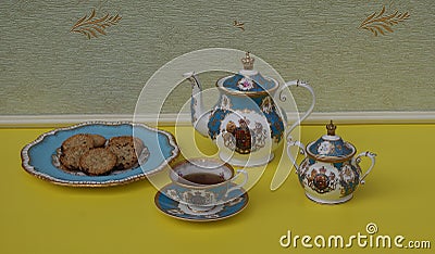 English teacup with saucer, teapot, sugar bowl and a cake plate with cookies, fine bone china porcelain Stock Photo