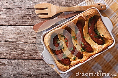 English food: toad in the hole into a baking dish. horizontal to Stock Photo