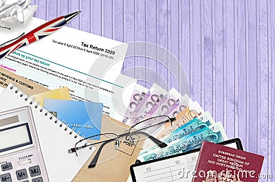 English form sa100 Tax return by HM revenue and customs lies on table with office items. HMRC paperwork and tax paying process in Editorial Stock Photo