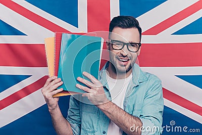English language learning concept-portrait of cheerful attractive man with bristle showing colorful copy books standing over Engli Stock Photo
