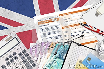 English Tax form P60 End of year certificate by HM revenue and customs lies on table with office items. HMRC paperwork and tax Editorial Stock Photo