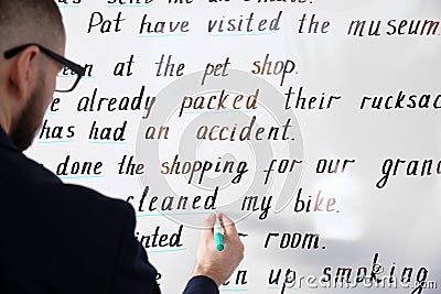 English teacher underlining word on whiteboard at lesson, closeup Stock Photo