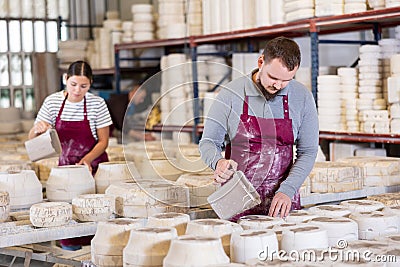 Potter filling casting molds with slip to shape ceramic products Stock Photo