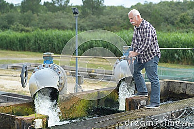 Enior manual workerat valve at plant Stock Photo