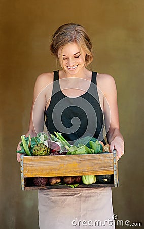 Enjoy the gifts of nature. A young woman holding a crate of vegetables outdoors. Stock Photo