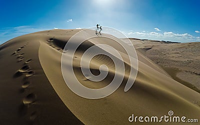 Enjoy people jumping on the sand dunes Stock Photo
