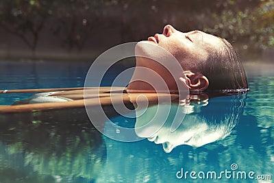 Enjoy the summer. Woman relaxing in the pool water Stock Photo