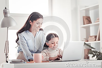 Pretty young mother spending unforgettable family time playing with daughter Stock Photo