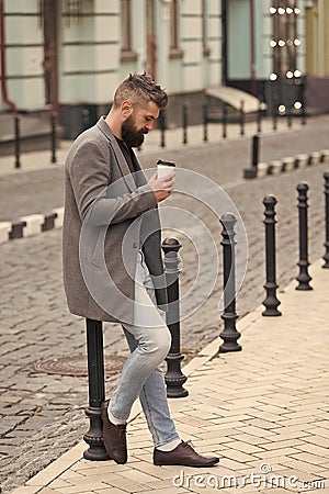 Enjoying coffee time. Walk and enjoy fresh hot coffee. Waiting for someone in street. Man bearded hipster drink coffee Stock Photo