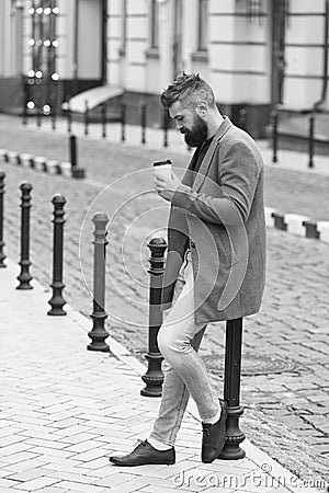 Enjoying coffee time. Walk and enjoy fresh hot coffee. Waiting for someone in street. Man bearded hipster drink coffee Stock Photo