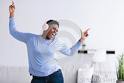 Black woman listening to music in headphones and dancing Stock Photo