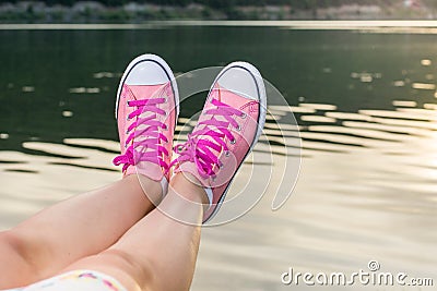 Enjoying by lake. Woman wearing pink sneakers Stock Photo