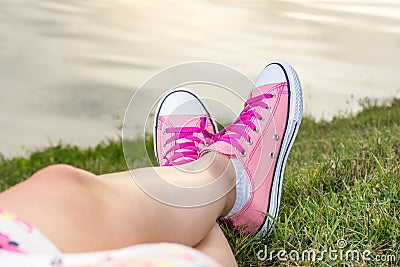 Enjoying by lake. Woman wearing pink sneakers Stock Photo