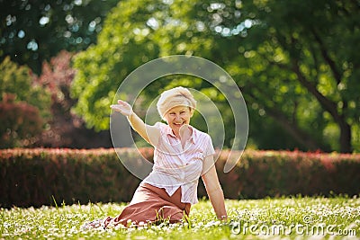 Enjoyment. Positive Emotions. Outgoing Old Woman Resting on Grass Stock Photo