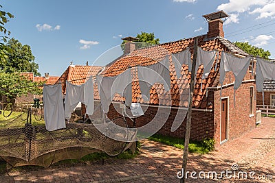 Enkhuizen, Netherlands. June 2022. Talking fishermen men and women and the backdrop of drying laundry. Editorial Stock Photo