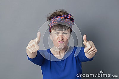 Enraged woman frowning with thumbs up for fighting success Stock Photo