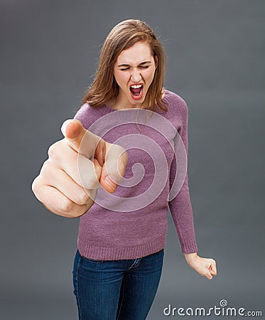 Enraged young woman screaming, pointing a bossy over sized finger Stock Photo