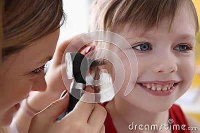 Ent doctor examining sore ear of small child using otoscope Stock Photo