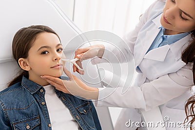 Attentive ent physician examining nose of Stock Photo