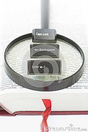 Enter, Backspace, CapsLock Computer Keys on a magnifying glass Stock Photo