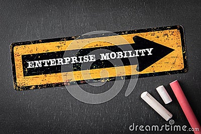 Enterprise Mobility. Yellow directional arrow with text on a dark chalkboard background Stock Photo