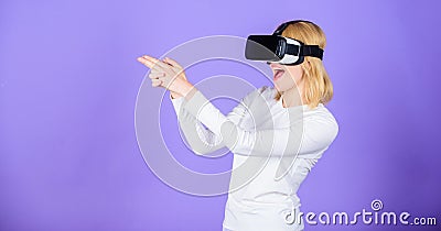 Enthralling interaction virtual reality. Woman head mounted display violet background. Virtual reality shooting gallery Stock Photo