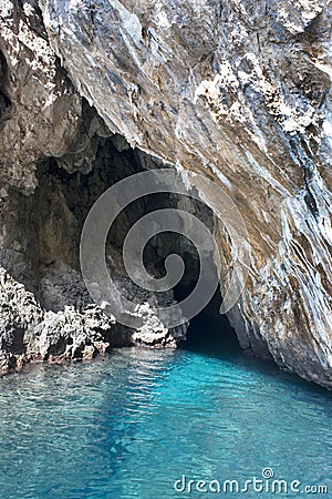 Enthralling sea cave in the calcareous cliff outcropping on an aquamarine sea. Stock Photo