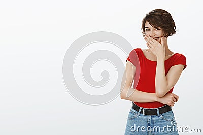 Enthusiastic cheerful pretty tender young woman pixie short haircut giggle cover mouth smiling broadly over funny friend Stock Photo