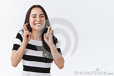 Enthusiastic, hopeful young girl keep faith, feeling lucky and amused as awaiting something important, begging for good Stock Photo