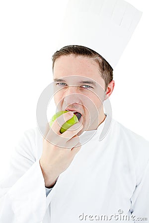 Enthusiastic male cook eating a green apple Stock Photo