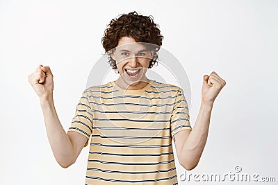 Enthusiastic male model showing winner pose, celebrating victory, screaming from excitement, white background Stock Photo