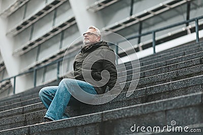 An enthusiastic pensioner. The older man sits and enjoys the silence. Comfortable relaxation and tranquility Stock Photo