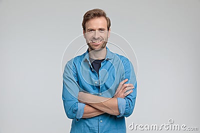 Enthusiastic young casual man crossing arms and smiling Stock Photo