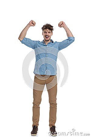 Enthusiastic young casual man holding hands in the air Stock Photo