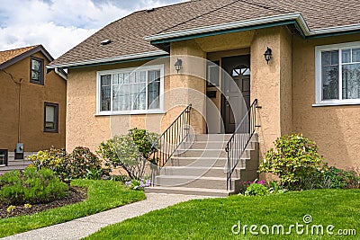 Entrance of average family house with green lawn in front Stock Photo