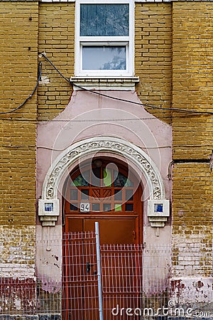 The entrance door of an old brick building with stucco molding, a fragment of the facade Stock Photo