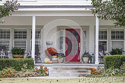 Entrance and porch to pretty house with Autumn and Halloween decorations and fall leaves blowing in the wind - curb appeal Stock Photo